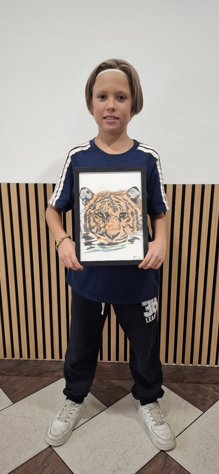Emilio mostra il suo disegno preferito: una tigre in una cornice nera.